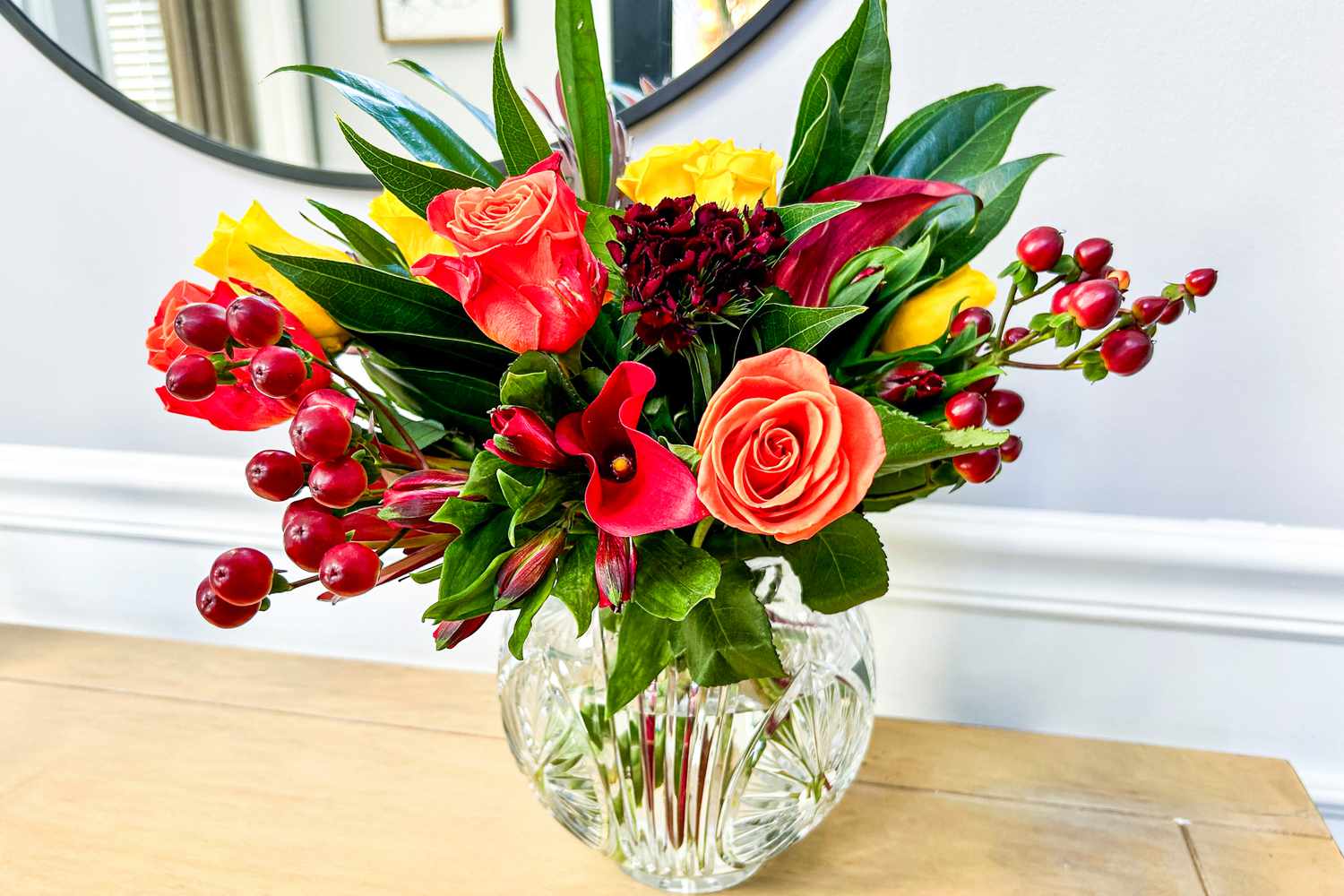 Flowers from the BloomsyBox in a vase on a wooden surface