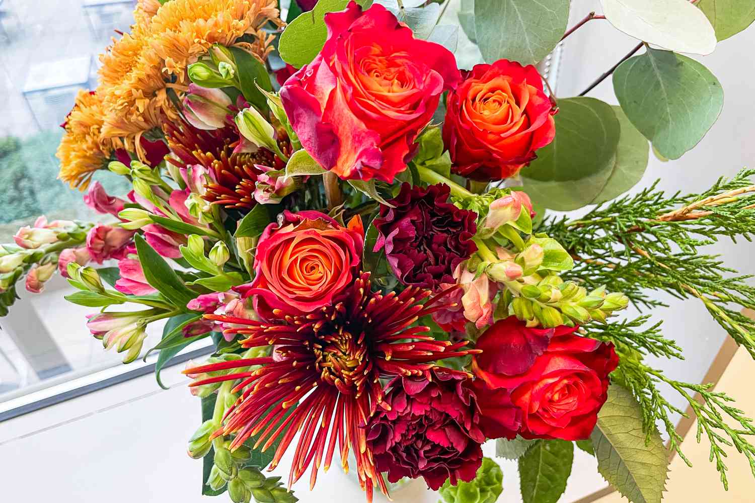 A close-up of a bouquet from Enjoy Flowers by a window