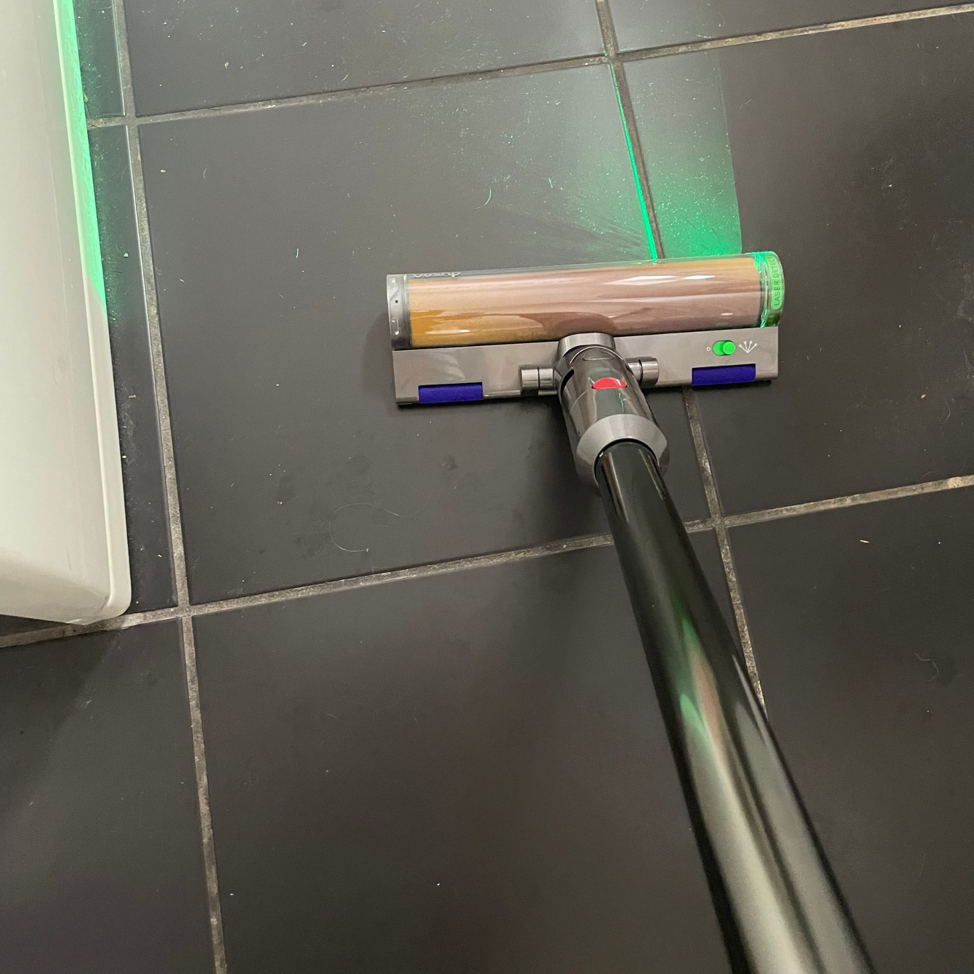 Using the Dyson V12 on the grey tiles in a bathroom