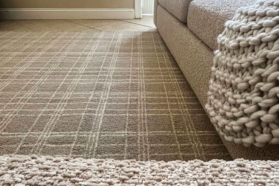 The Better Homes & Gardens Beige Plaid Wool Indoor Area Rug under furniture