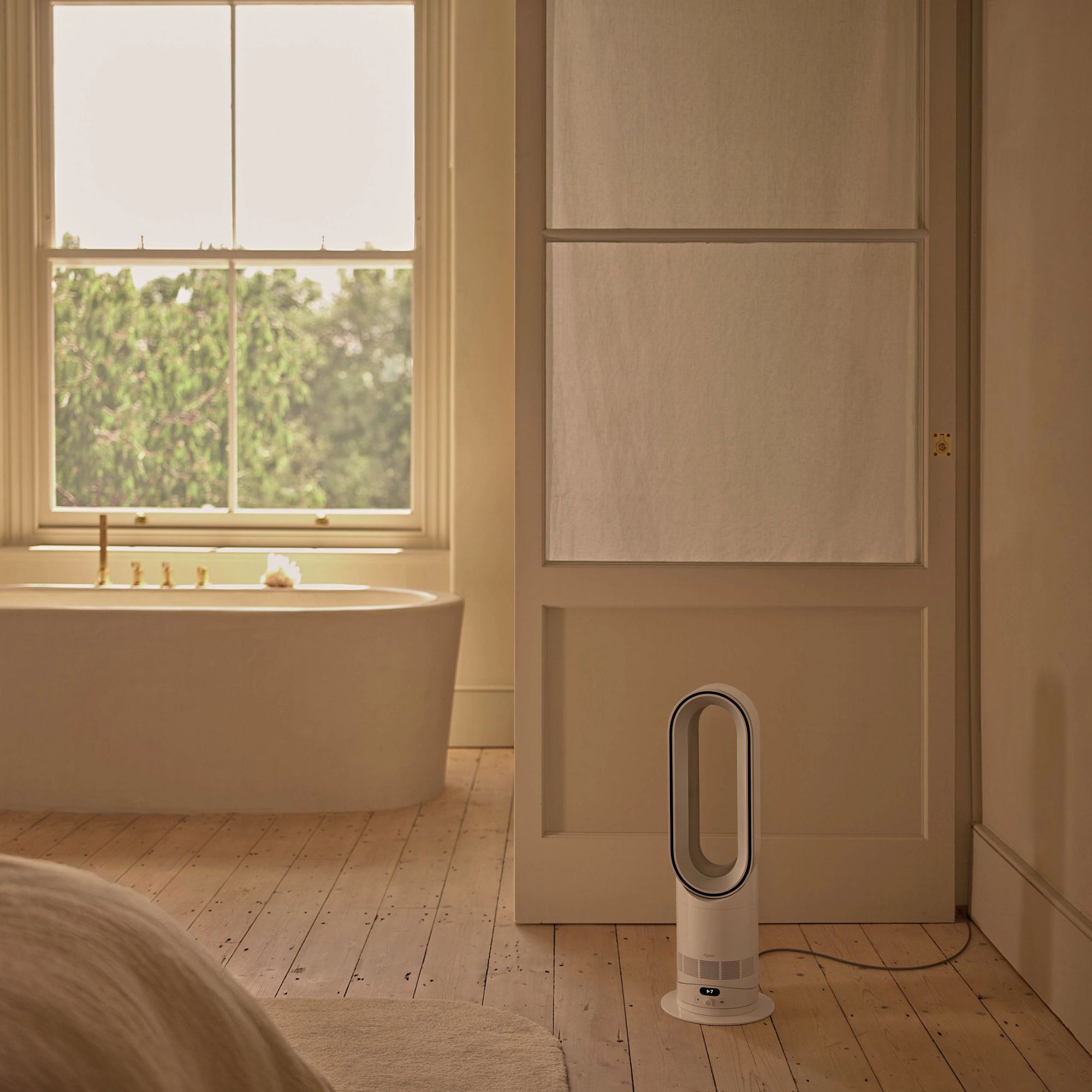 Dyson Hot+Cool HF1 Fan Heater  on the floor in a bathroom with wooden floors and a freestanding tub