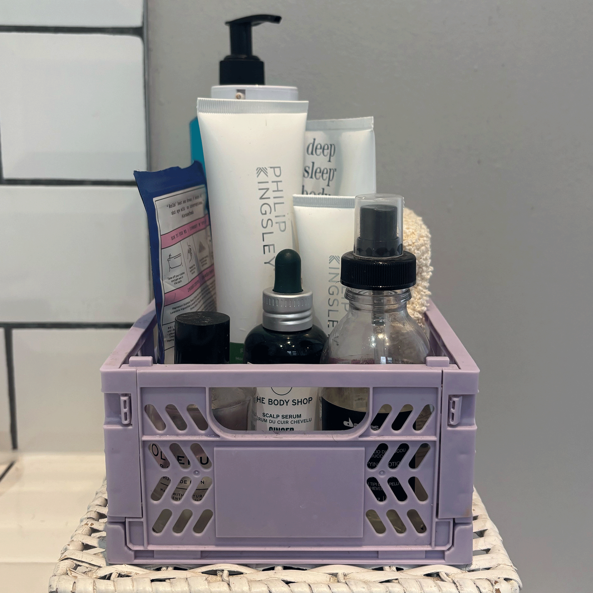Colourful Primark storage crate in purple holding toiletries in white bathroom