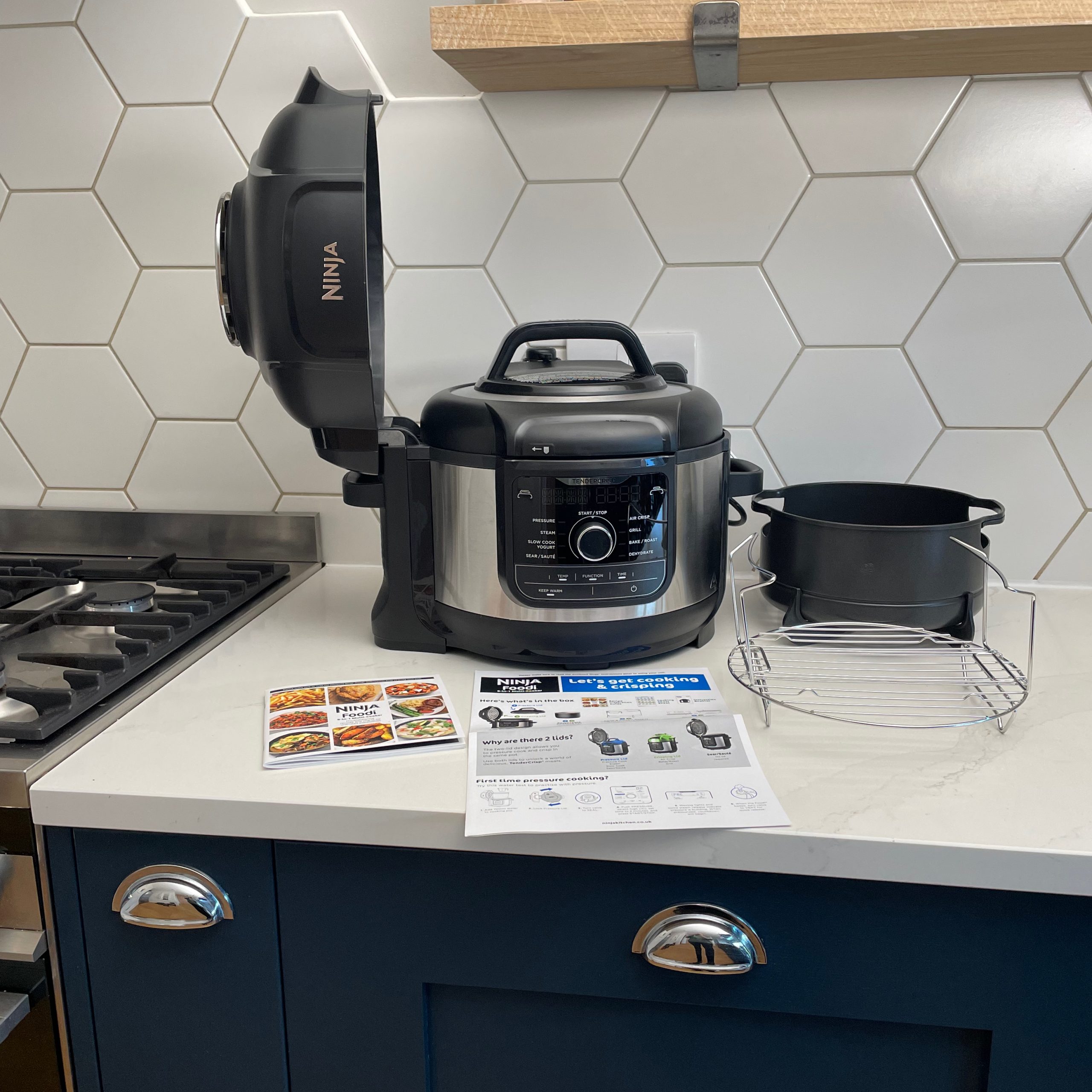 Ninja Foodi 9-in-1 Multi-Cooker open with instruction manual on white kitchen counter