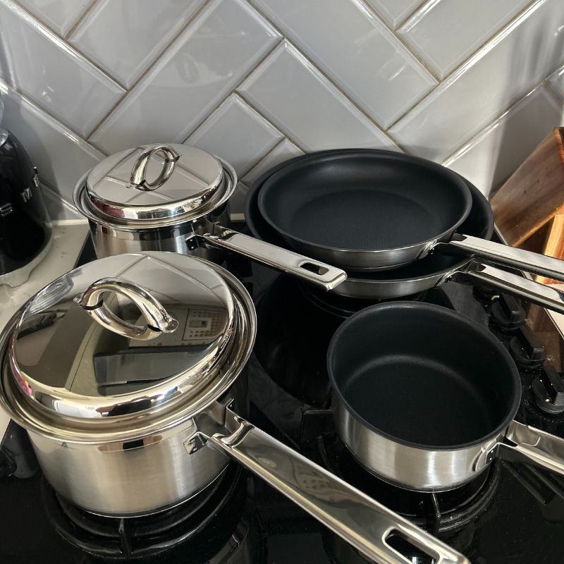 John Lewis Classic 5 Piece Pan Set unboxed, on hob