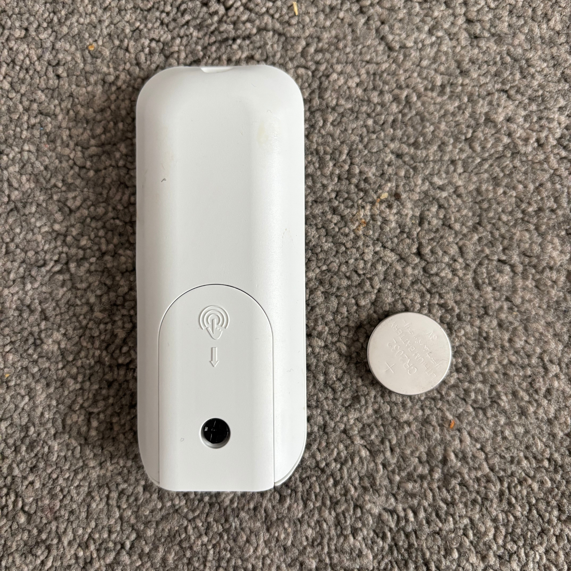 back view of the Duux Edge Oil 2000W Oil-Filled Radiator remote and round silver battery