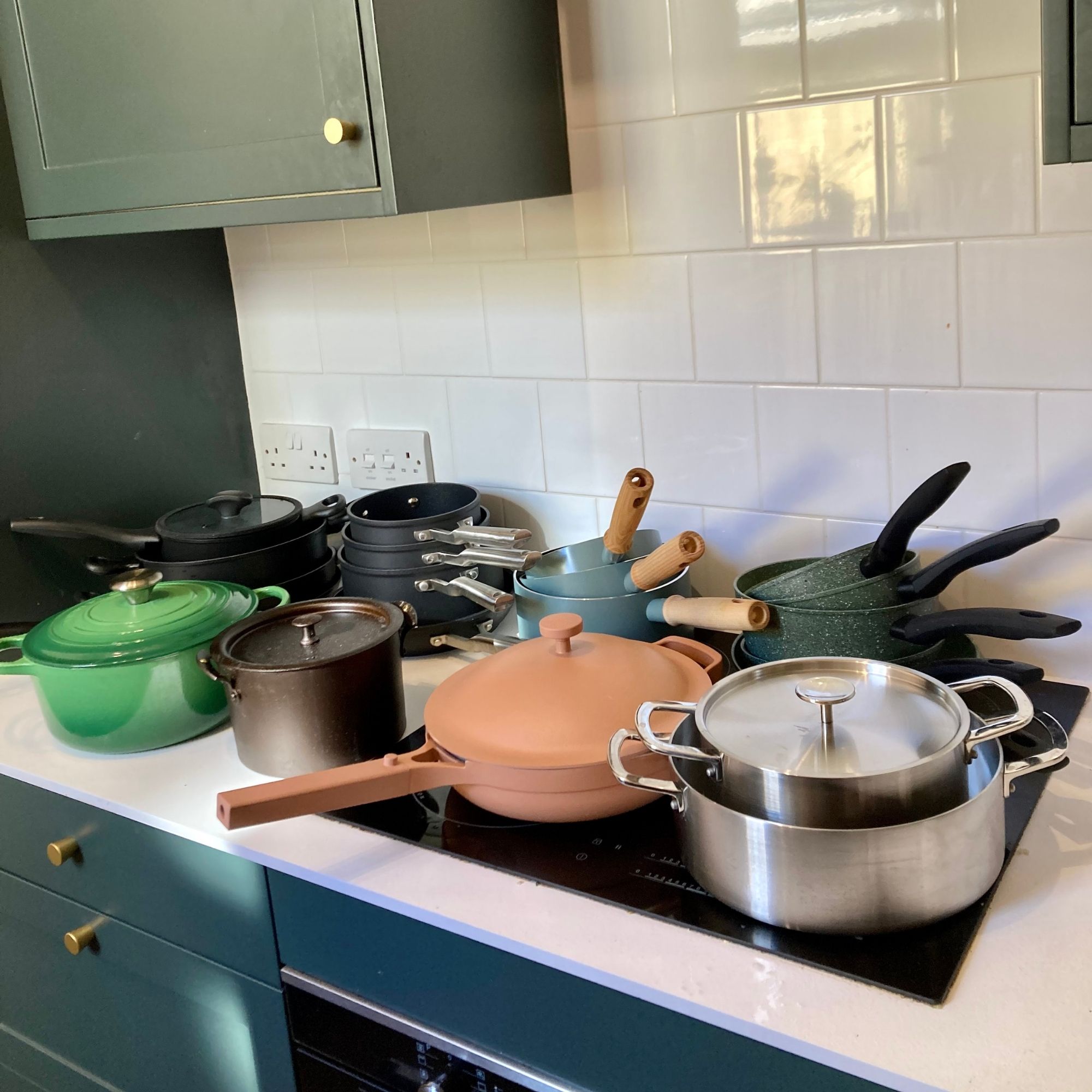 Multiple pots and pans on the top of a kitchen counter and stove