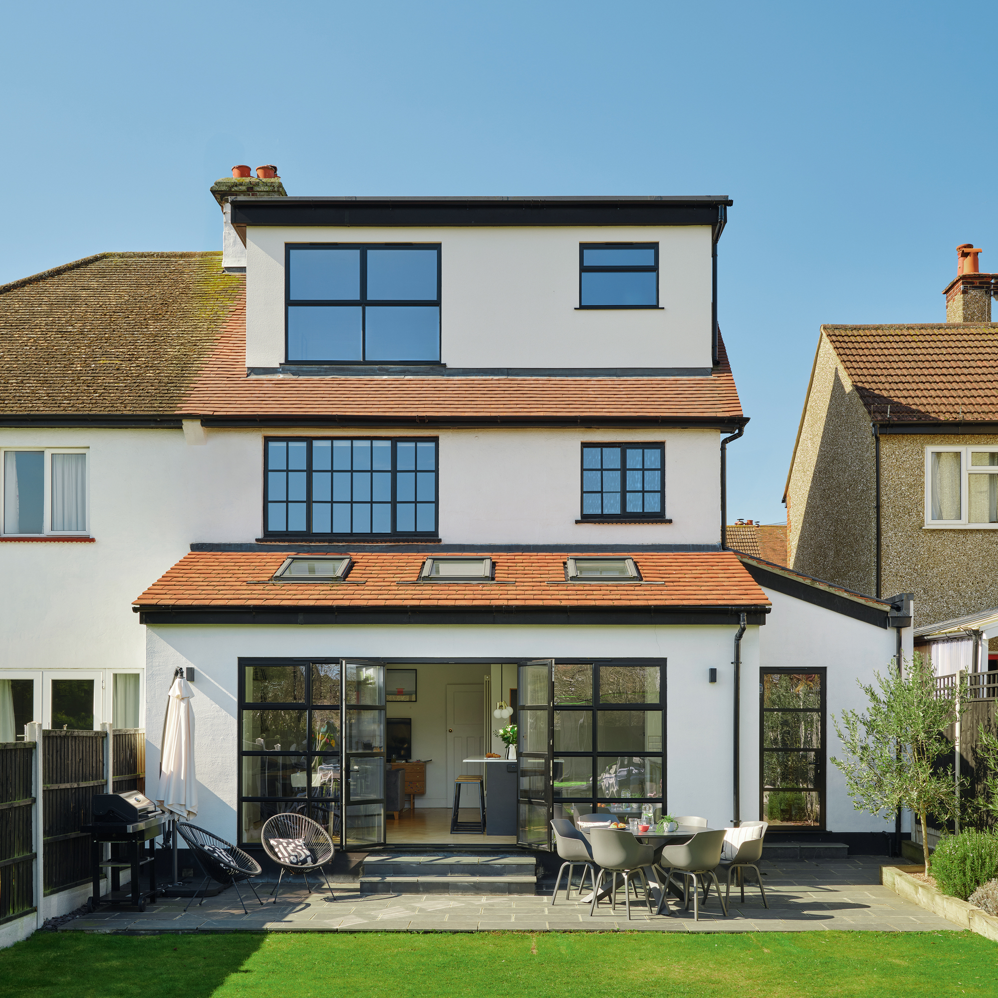 the rear view of a newly renovated three storey house