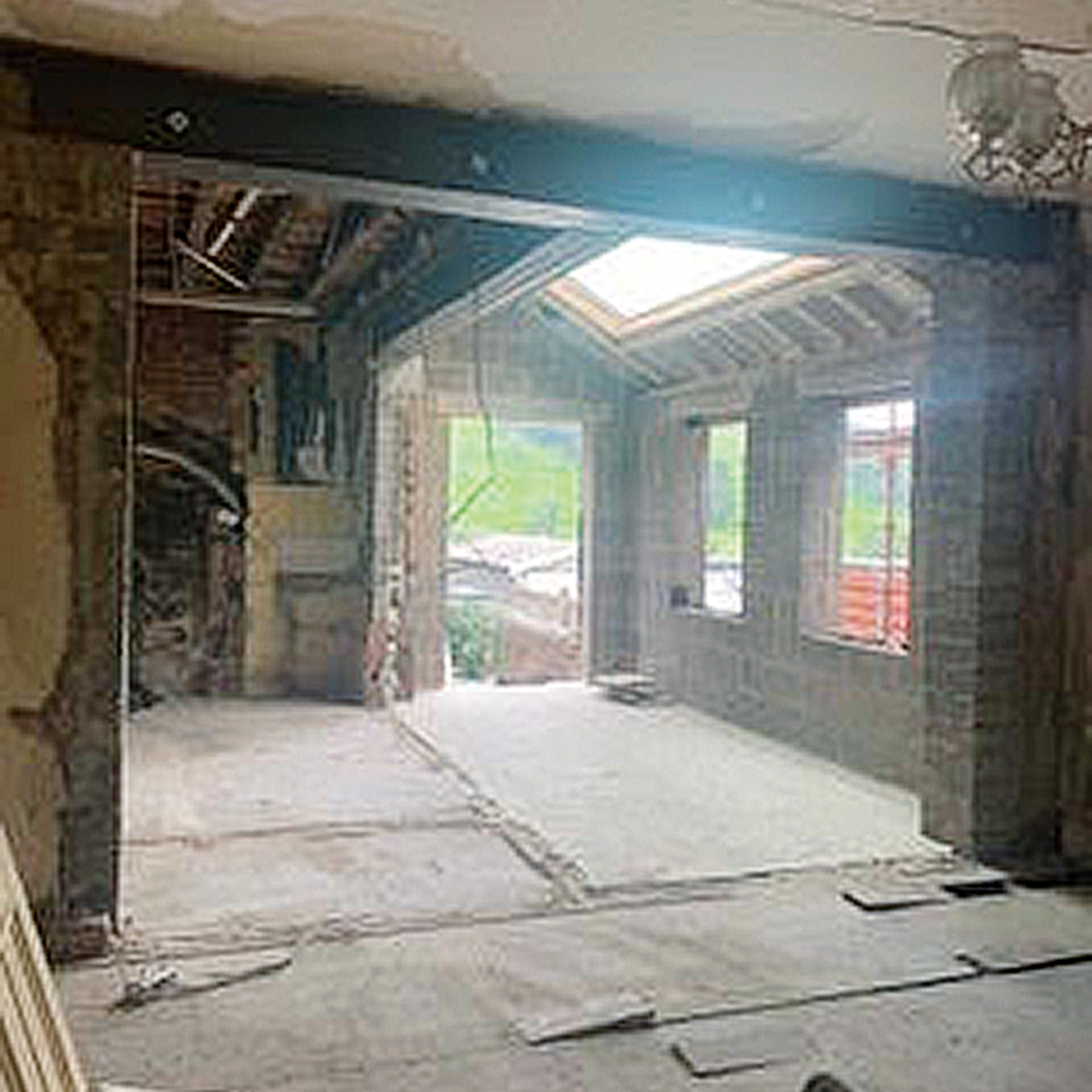 empty extension with exposed walls and boarded floor