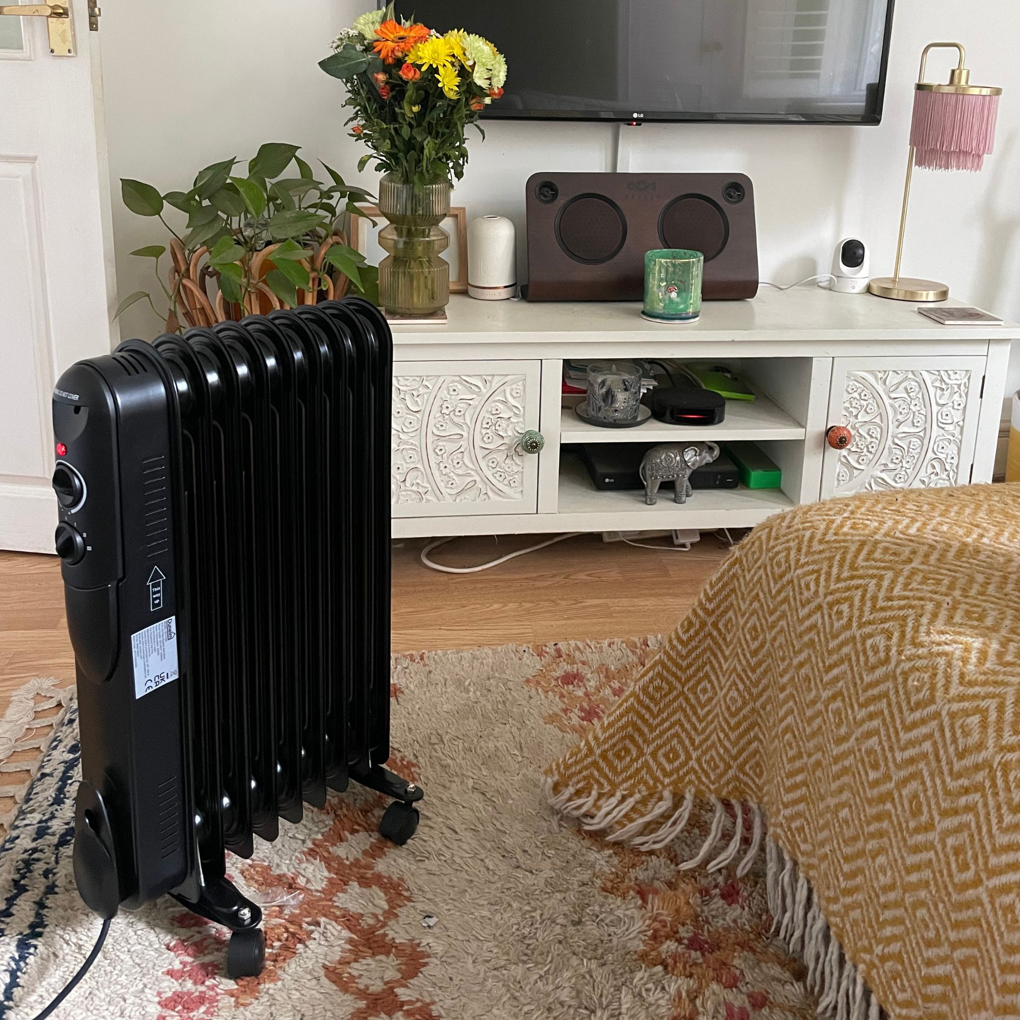 Dunelm oil-filled radiator in a living room, with a tv unit and TV behind it
