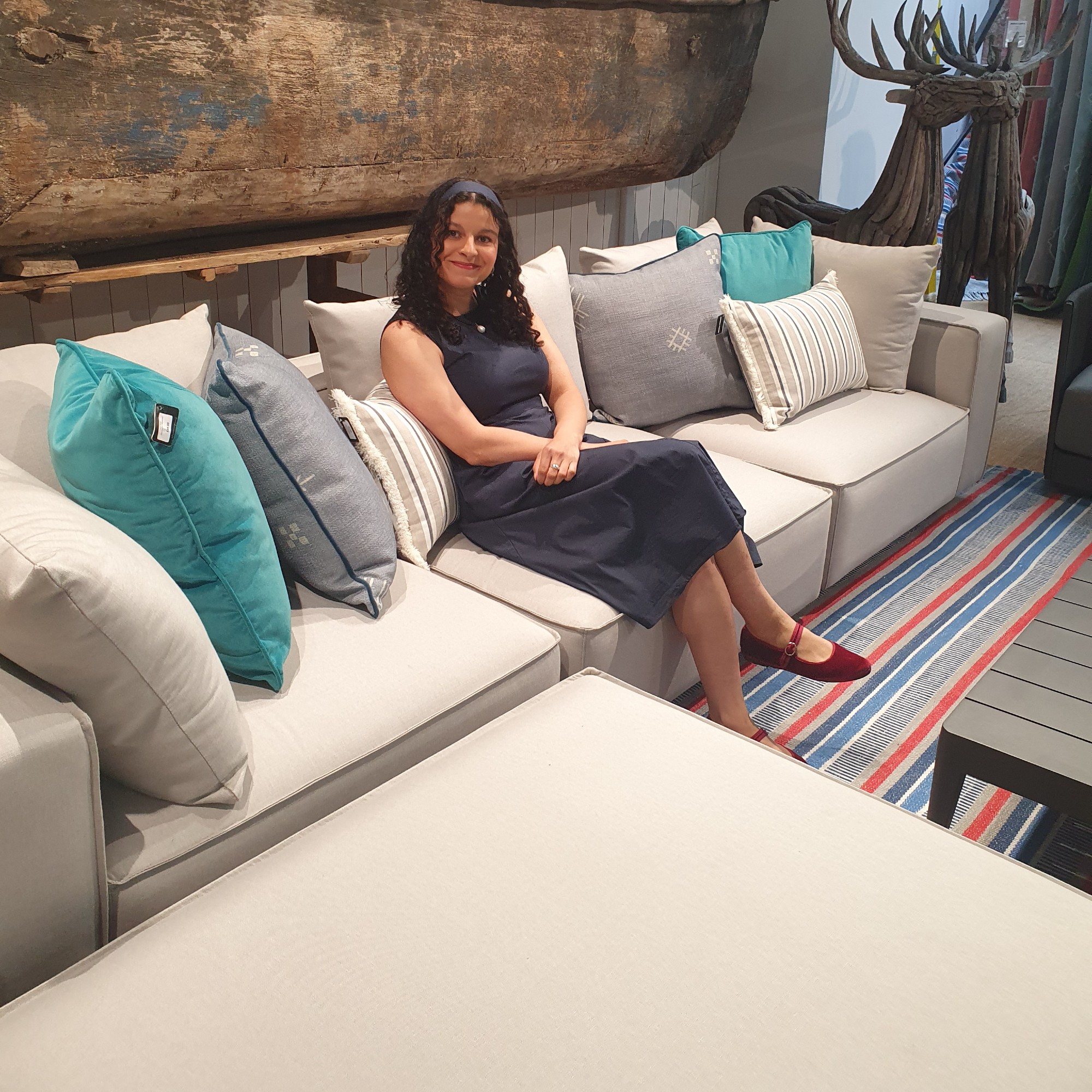 Sara sitting on an outdoor modular sofa at the Andrew Martin showroom