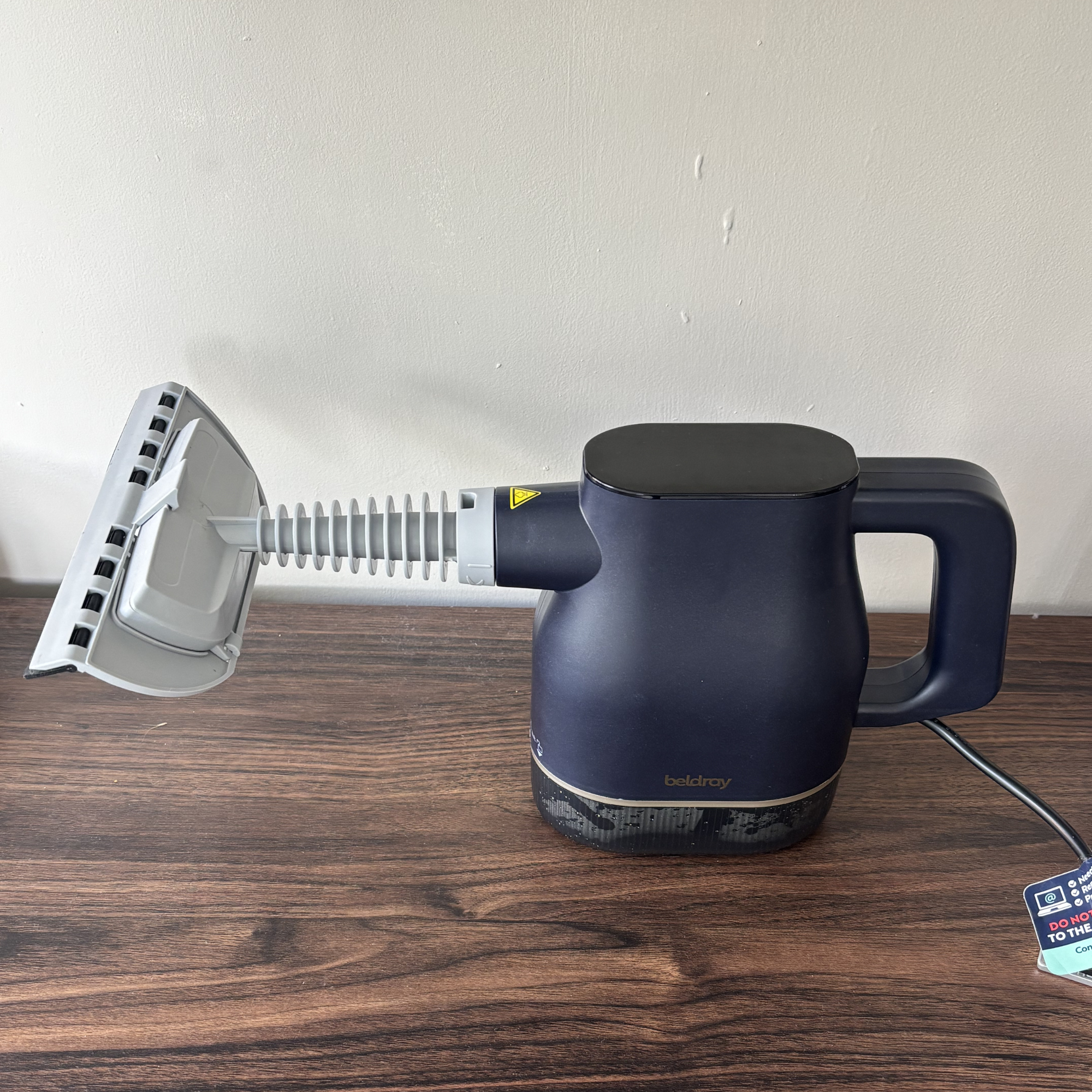 Beldray Digital Handheld Steam Cleaner on wood sideboard 