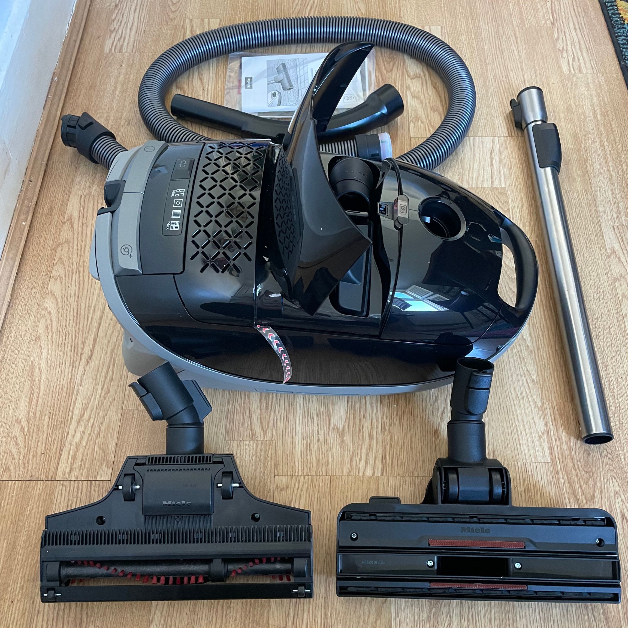 Miele Guard M1 Cat & Dog components laid out on laminate flooring