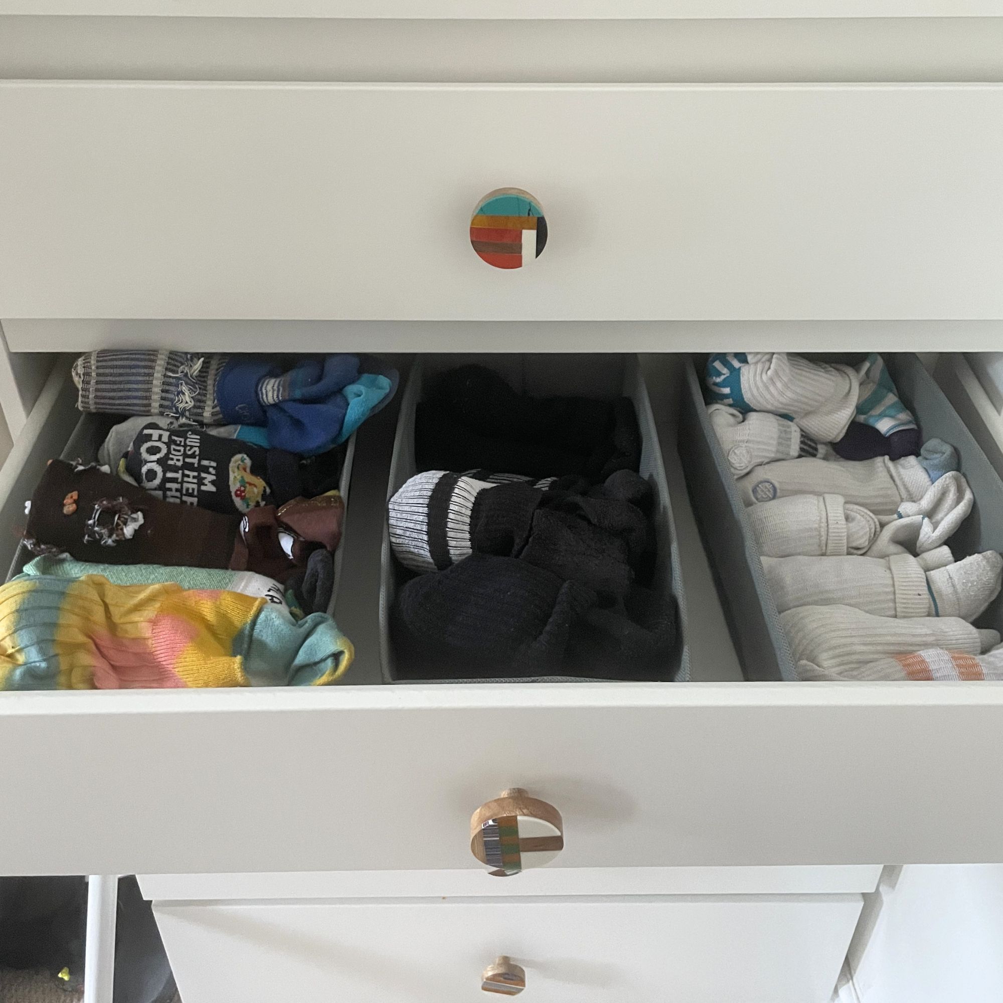 Socks in drawer organisers in a white chest of drawers